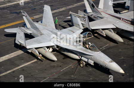 Un US Navy F/A-18C Hornet parcheggiata sul ponte di volo della portaerei USS Nimitz. Foto Stock