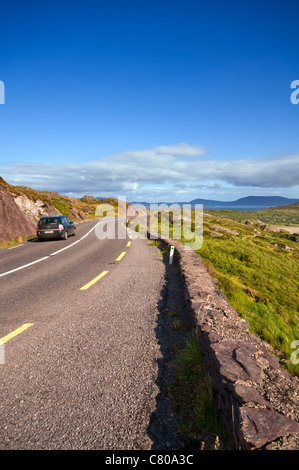 Un auto guidando lungo il Ring of Kerry vicino a Waterville nella Contea di Kerry, Irlanda Foto Stock