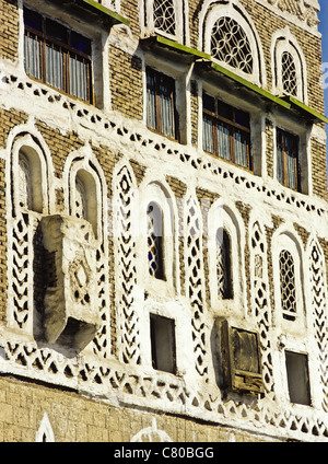 Dettagli architettonici che mostra tracery windows di un abitazione multipiano nella città vecchia di Sana'a, Yemen Foto Stock