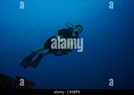 Scuba Diver utilizza un subacqueo del veicolo a propulsione per navigare nelle acque al largo della costa di Bonaire, dei Caraibi Paesi Bassi. Foto Stock