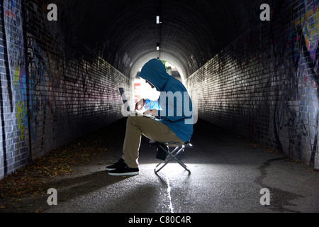 Il computer utente, hacker, siede conspiratorially, in un tunnel con un computer portatile. Immagine di simbolo, computer-la criminalità su Internet. Foto Stock