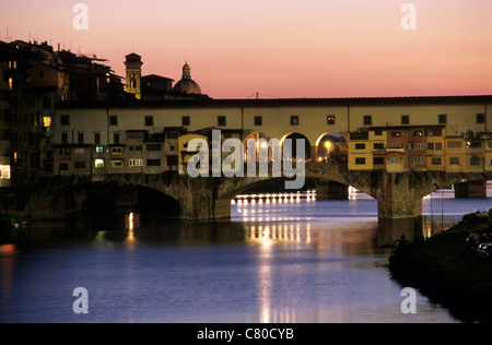 L'Italia, Toscana, Ponte Vecchio oltre il fiume Arno a Firenze al tramonto Foto Stock