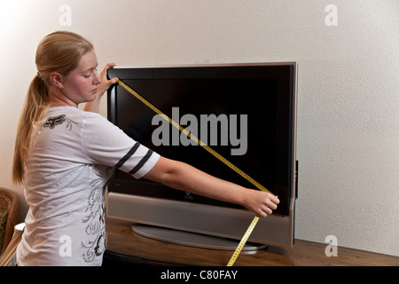 Ragazza adolescente misure delle dimensioni di un centimetro 80 sullo schermo del televisore. Signor © Myrleen Pearson Foto Stock