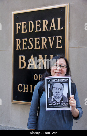 Donna che mantiene occupano Chicago flier al di fuori della Federal Reserve Bank. Occupare la protesta di Chicago. Foto Stock