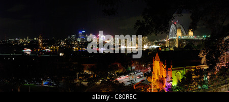 Tempo di notte vista panoramica sullo skyline di Sydney che mostra Harbour Bridge e storica area di Rocks in primo piano. Vecchia chiesa Garrison Foto Stock