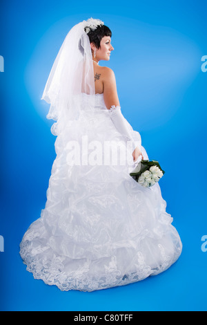 Una bella e felice sposa su sfondo blu. Foto Stock