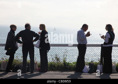 I delegati della conferenza di mangiare il pranzo con il mare in background Foto Stock
