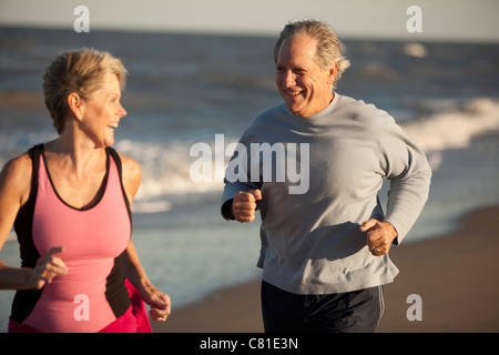 Matura in esecuzione insieme sulla spiaggia Foto Stock