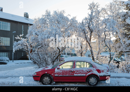 Auto rossa nel sole invernale. Down Town Reykjavik, Islanda Foto Stock