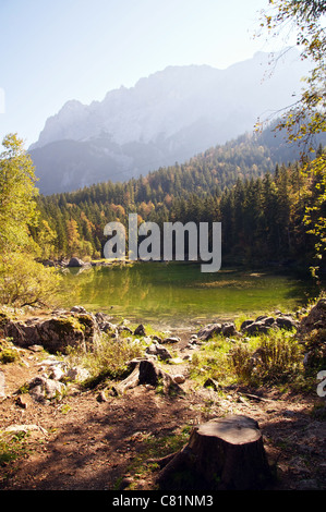 Sulla riva di un piccolo lago ai piedi delle Alpi Bavaresi in inizio di caduta Foto Stock