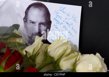 I fan di lasciare i fiori e le mele con un boccone fuori di loro al di fuori dei negozi Apple Store a Londra in seguito alla morte di Steve Jobs Foto Stock