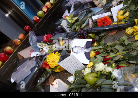 I fan di lasciare i fiori e le mele con un boccone fuori di loro al di fuori dei negozi Apple Store a Londra in seguito alla morte di Steve Jobs Foto Stock
