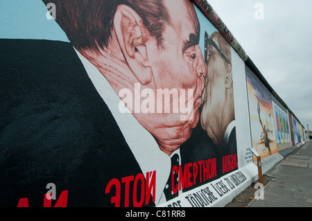 Immagine iconica sul tratto superstite del muro di Berlino che mostra presidente sovietico Leonid Brezhnev baciare il leader della DDR Erich Honecker Foto Stock