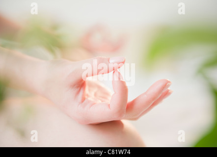 Close up della donna coreana le mani facendo gesto di yoga Foto Stock