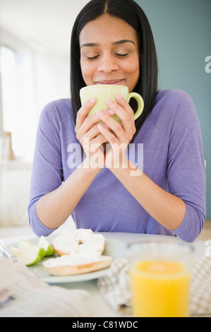 African American donna di bere il caffè con prima colazione Foto Stock