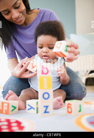 African American madre e figlio giocare con i blocchi di alfabeto Foto Stock