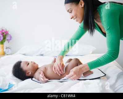 African American madre modifica figlio il pannolino Foto Stock