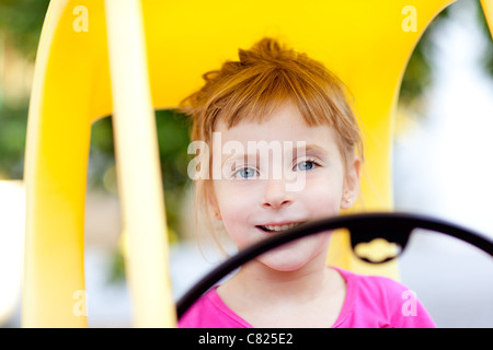 Blonde Bambini ragazza guida auto giocattolo giallo Foto Stock