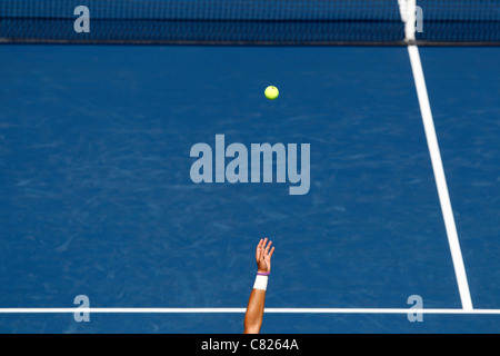 Servizio di tennis, il braccio nel lanciare la palla in aria di fronte al netto a US Open 2011 Torneo di tennis Foto Stock