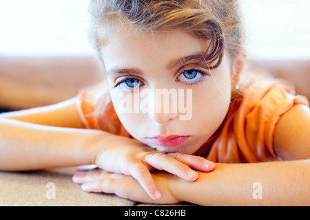 Blue eyes triste Bambini ragazza bracci incrociati sul tavolo Foto Stock