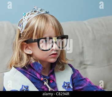 Bambina con il nero nerd bicchieri e la tiara. Foto Stock