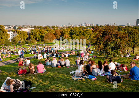 Persone relax su molto caldo pomeriggio su Primrose Hill, London, Regno Unito Foto Stock