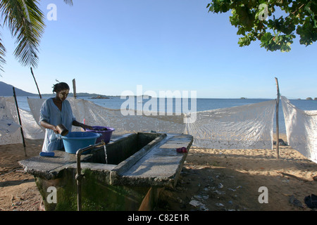 Madagascar donna malgascia il lavaggio della biancheria sulla spiaggia di Nosy Komba isola Foto Stock