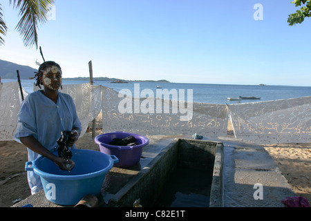 Madagascar donna malgascia il lavaggio della biancheria sulla spiaggia di Nosy Komba isola Foto Stock