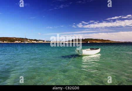 Piccola barca bianca galleggiante nel canale tra bryher e tresco isole Scilly Foto Stock