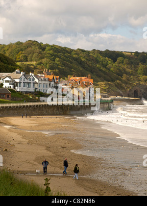 Persone che esercitano i loro cani in autunno il sole sulla spiaggia a Sandsend vicino a Whitby North Yorkshire Foto Stock