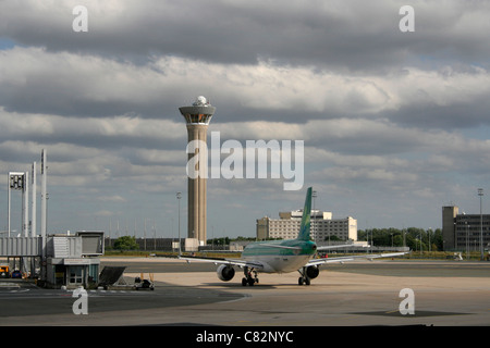 Aer Lingus Airbus A320 taxiing per la partenza in vista della torre di controllo all'aeroporto Charles de Gaulle di Parigi. Aeroporti dell'Unione europea. Foto Stock