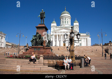 Coppia seduta su una panchina sotto la statua dell'Imperatore Alessandro II al di fuori di Helsinki la cattedrale, la Piazza del Senato, Helsinki, Finlandia Foto Stock