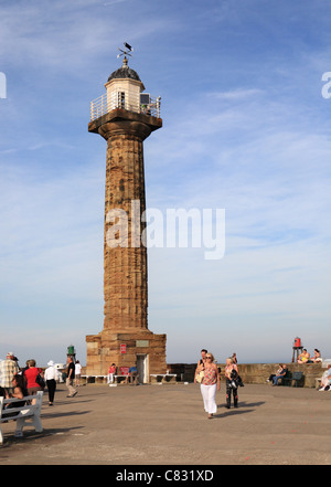 La gente camminare vicino al faro sul molo di Whitby Foto Stock