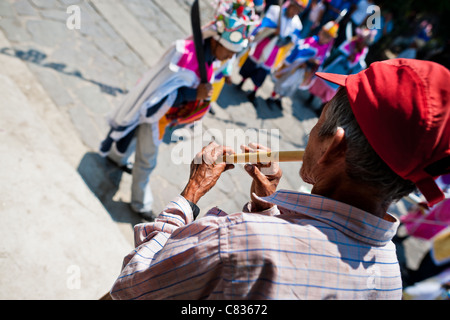 Un uomo di Salvadoran suona il flauto durante la processione del fiore & palm festival in panchimalco, El Salvador. Foto Stock