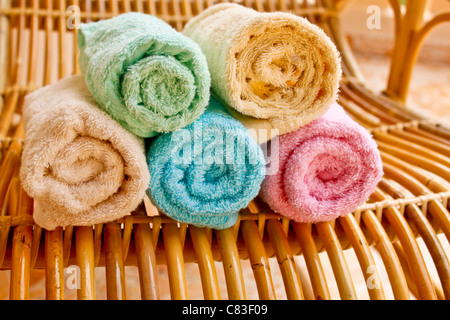 Asciugamani multicolore rotoli sulla sedia di legno Foto Stock