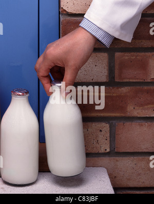 Lattaio consegnare latte su una porta. Foto Stock