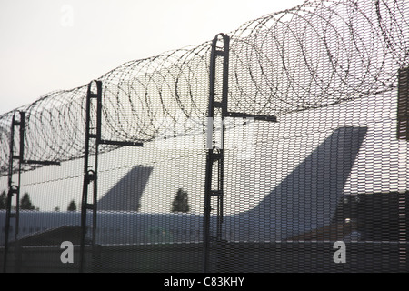 Aeroplani a Heathrow Airport dietro un muro di sicurezza Foto Stock