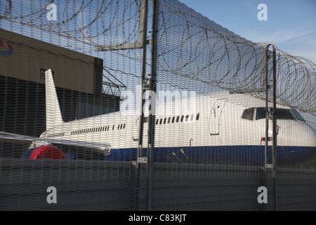 Aeroplani a Heathrow Airport dietro un muro di sicurezza Foto Stock