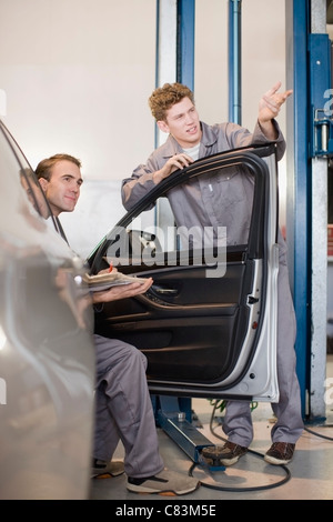 I meccanici che lavorano in garage Foto Stock