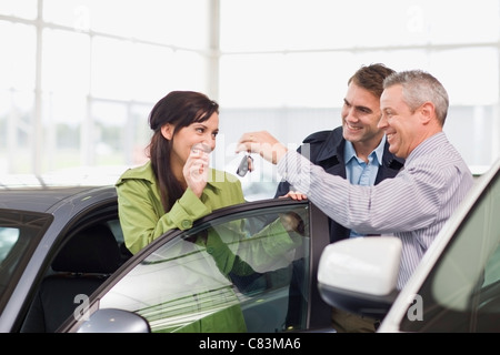 Venditore auto che dà le chiavi per il cliente Foto Stock