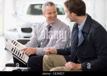 Venditore auto a parlare con il cliente Foto Stock