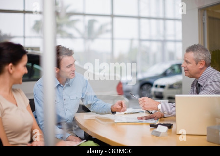 Venditore auto dando carte per paio Foto Stock