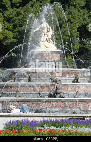 Turista che stabilisce presso la Fontana di Latona nei giardini di palazzo Herrenchiemsee, Herreninsel Chiemgau Chiemsee Alta Baviera Germania Foto Stock