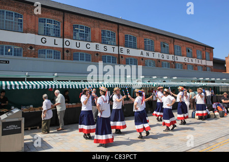 Un gruppo di ballerini di morris nella parte anteriore del mercato al centro theAntiques da Gloucester Quays, Gloucestershire, England, Regno Unito Foto Stock