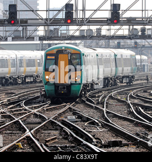 Treno passeggeri in avvicinamento alla stazione ferroviaria di London Bridge che attraversa i binari ferroviari e i binari sotto il segnale gantry South London Inghilterra Regno Unito Foto Stock