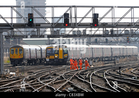 Gruppo di i lavoratori delle ferrovie sul binario elettrificato con i treni in arrivo e in partenza London Bridge stazione ferroviaria Foto Stock