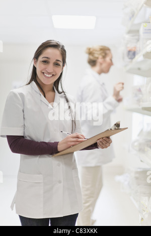 Infermiera sorridente holding negli appunti Foto Stock