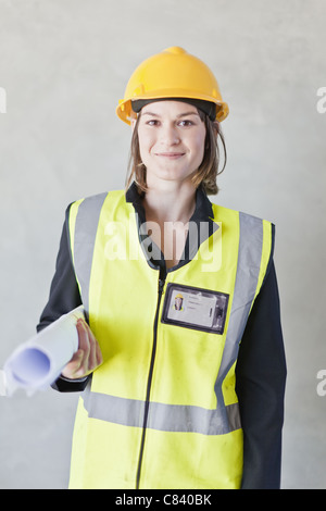 Lavoratore che trasportano blueprint sul sito Foto Stock