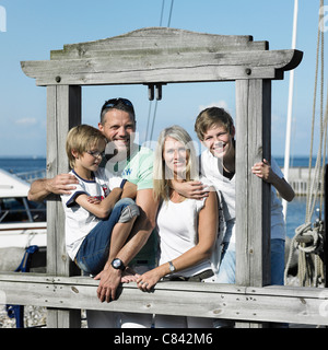Famiglia insieme sorridente sul molo Foto Stock