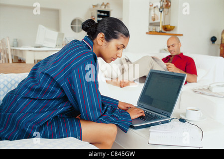 Donna facendo i compiti sul computer portatile Foto Stock